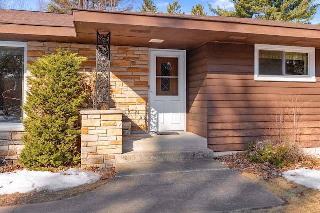 property entrance featuring stone siding