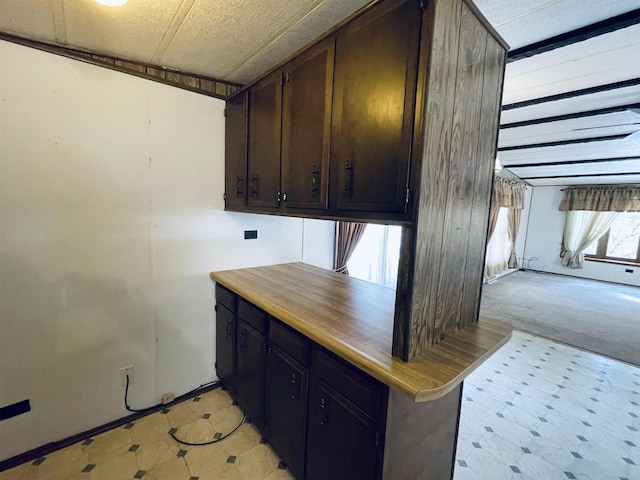 kitchen with light countertops and dark brown cabinetry