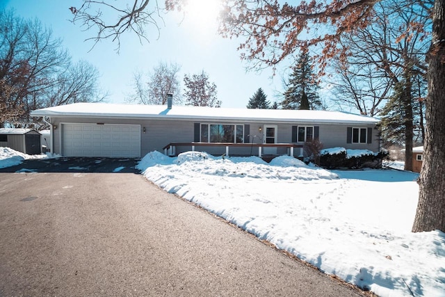 single story home with aphalt driveway and an attached garage