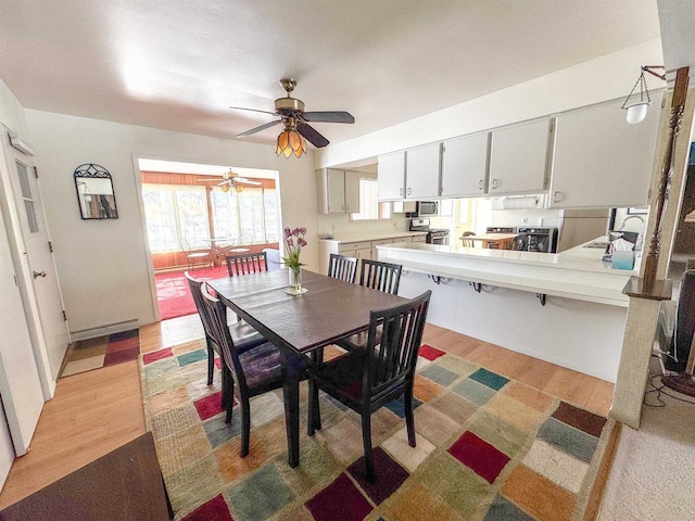 dining area featuring light wood-style floors and a ceiling fan