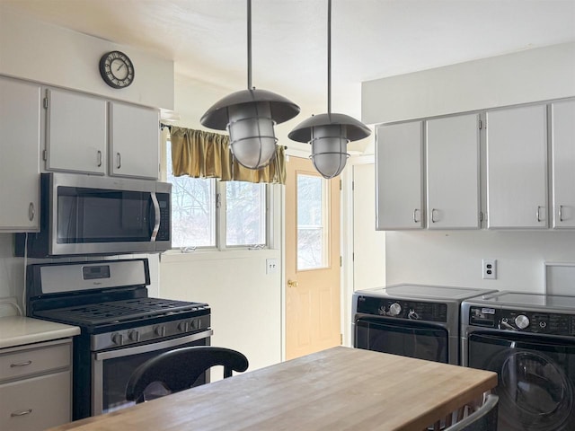 kitchen with washing machine and clothes dryer, light countertops, tasteful backsplash, and stainless steel appliances