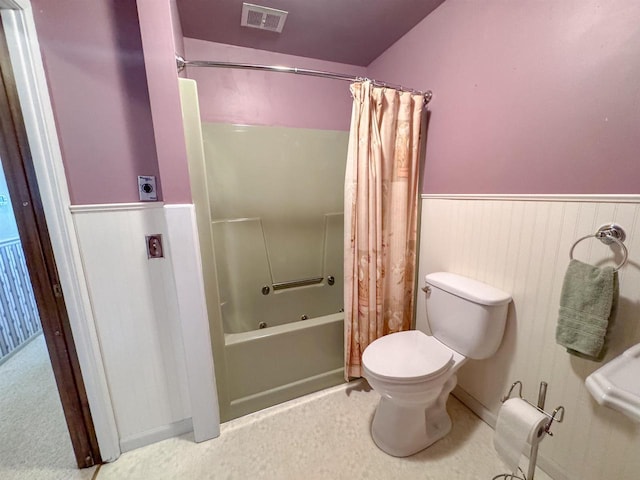 full bath with toilet, visible vents, shower / tub combo with curtain, and wainscoting