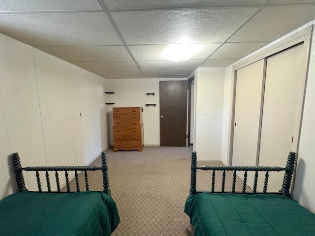 bedroom featuring a closet, carpet flooring, and a drop ceiling