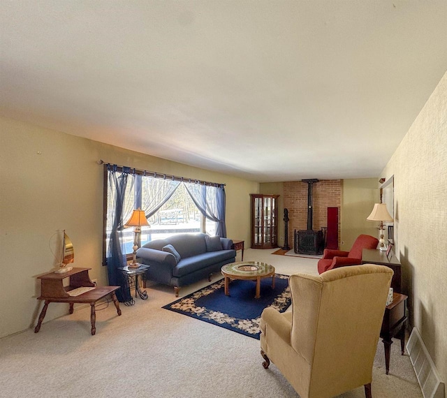 living area featuring visible vents, a wood stove, and carpet