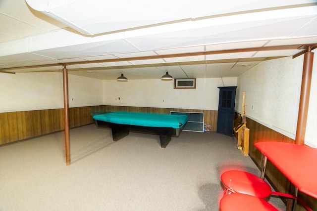 recreation room with carpet flooring, wood walls, and wainscoting