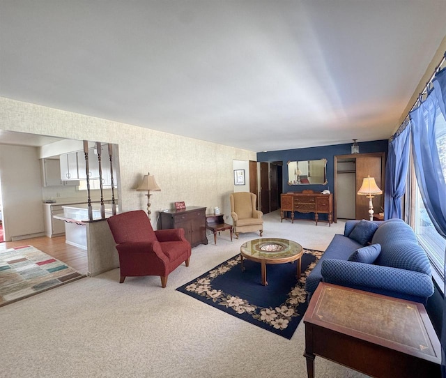 living room featuring wallpapered walls and carpet