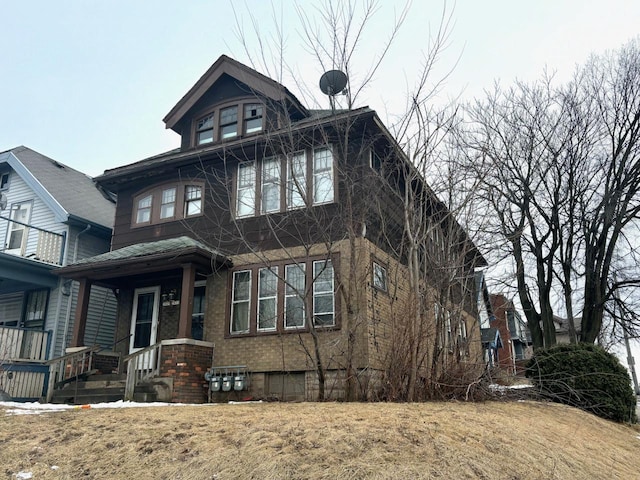 american foursquare style home featuring brick siding and a front yard