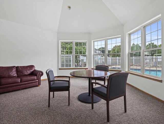 dining space featuring carpet floors, lofted ceiling, and baseboards