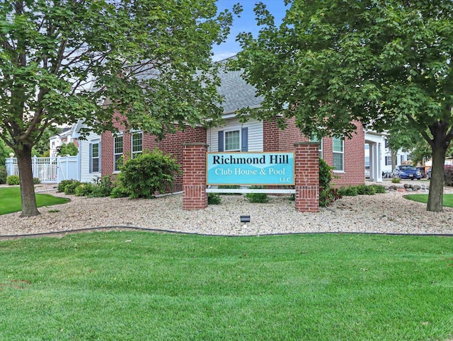 community / neighborhood sign featuring a lawn