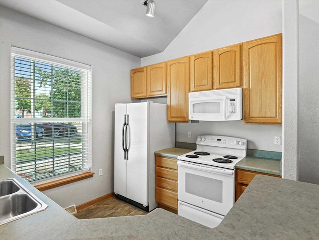 kitchen featuring lofted ceiling, white appliances, plenty of natural light, and light brown cabinetry