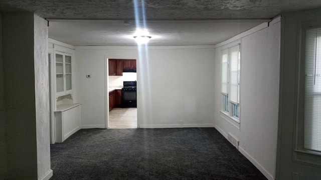 unfurnished room featuring baseboards and dark carpet