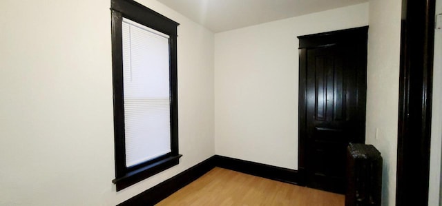 empty room with baseboards and wood finished floors