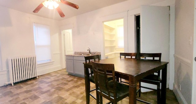 dining area featuring a ceiling fan and radiator heating unit