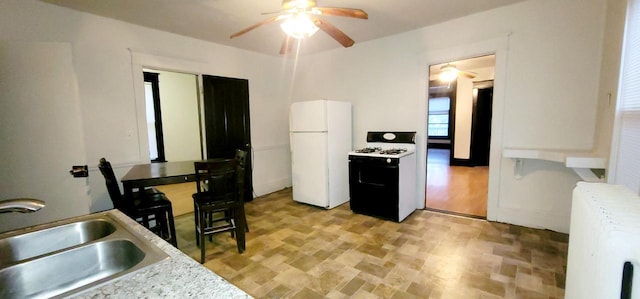 kitchen with white appliances, a sink, a ceiling fan, light countertops, and radiator heating unit