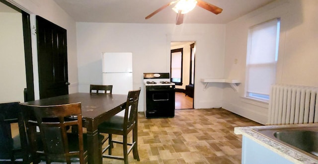 dining area with ceiling fan and radiator heating unit