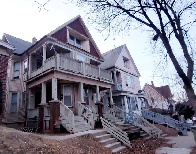 victorian-style house featuring a balcony, stairs, and a porch