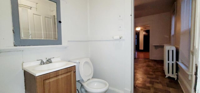 bathroom featuring toilet, vanity, and radiator