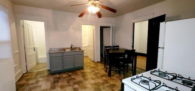 kitchen featuring gray cabinets, white appliances, a sink, and ceiling fan