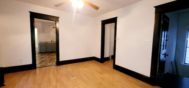 empty room with light wood-style floors, baseboards, and a sink