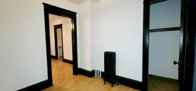 corridor with light wood-style flooring and baseboards