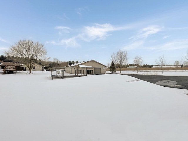 yard layered in snow featuring a garage