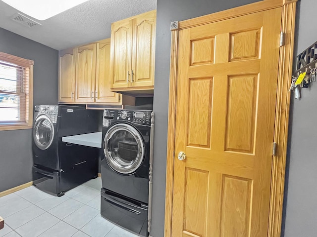 clothes washing area featuring light tile patterned floors, visible vents, cabinet space, a textured ceiling, and independent washer and dryer