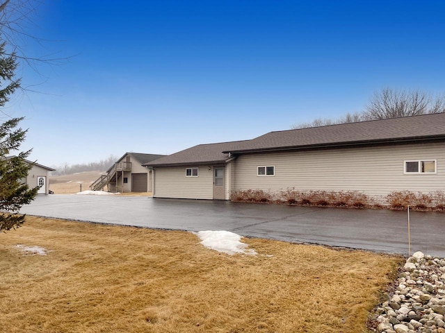 view of side of property with a yard and driveway