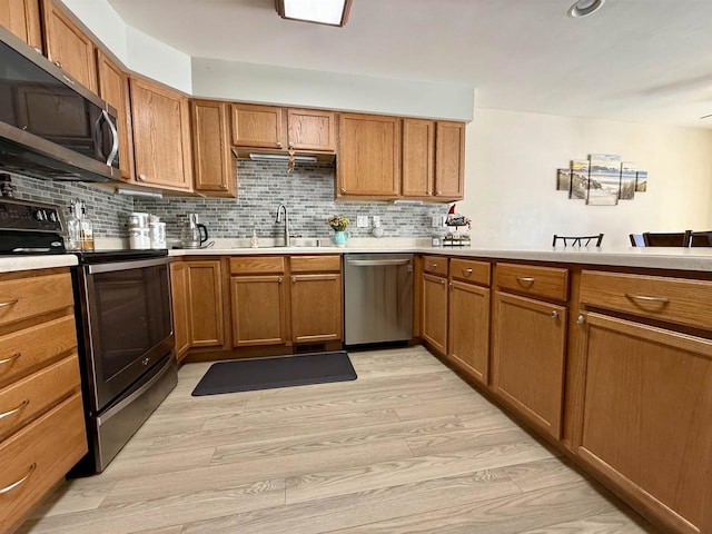 kitchen featuring appliances with stainless steel finishes, light countertops, and a sink