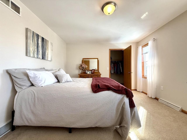 bedroom with baseboards, visible vents, a spacious closet, baseboard heating, and carpet floors