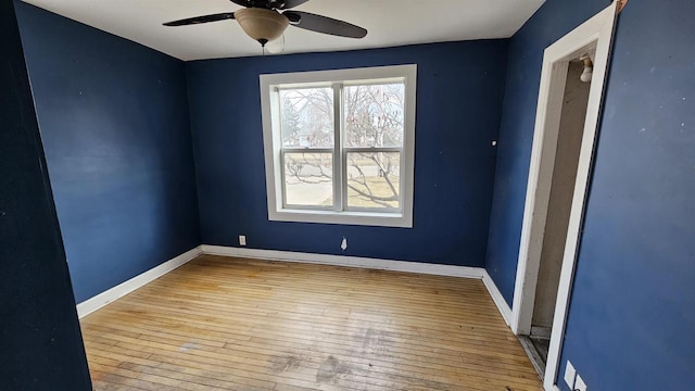 spare room featuring a ceiling fan, baseboards, and hardwood / wood-style floors