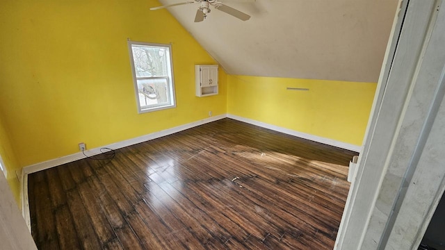 additional living space featuring a ceiling fan, vaulted ceiling, dark wood finished floors, and baseboards