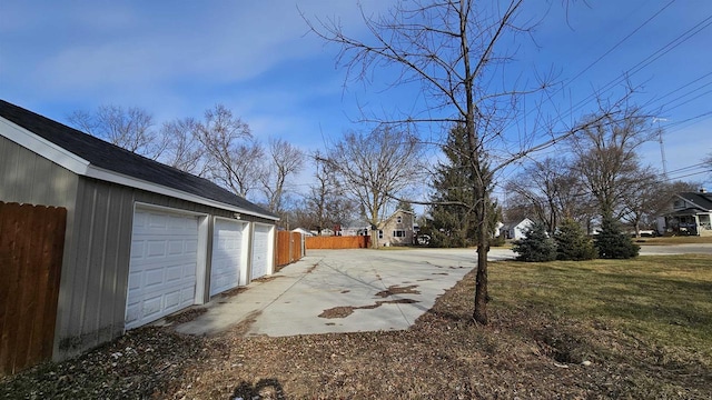 view of yard with an outdoor structure, community garages, and fence