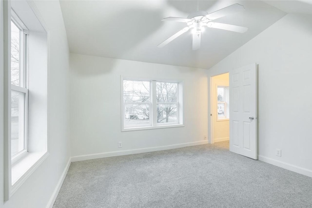 empty room featuring a ceiling fan, carpet, vaulted ceiling, and baseboards