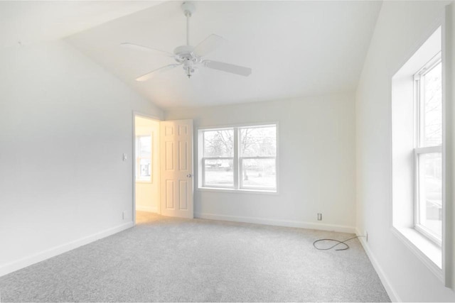 unfurnished room with lofted ceiling, light carpet, and baseboards