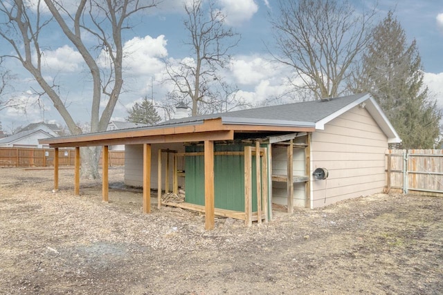 back of house with fence and an outdoor structure