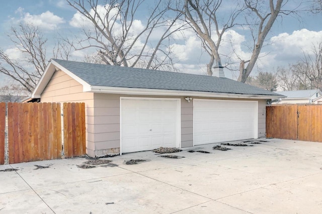 detached garage featuring fence