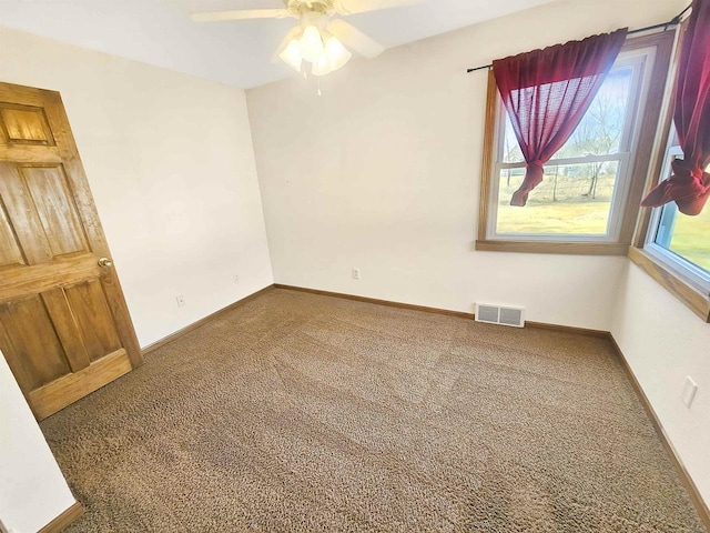 spare room featuring baseboards, visible vents, carpet floors, and ceiling fan