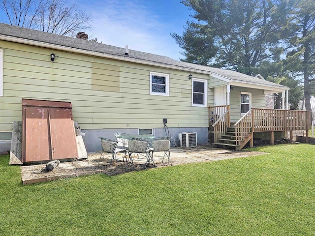 back of property with a patio, cooling unit, a wooden deck, a yard, and a chimney