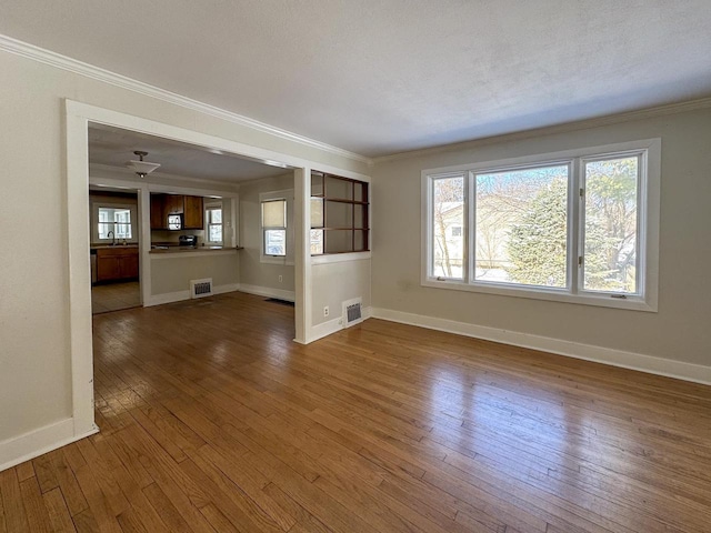 unfurnished living room with visible vents, dark wood-style flooring, and ornamental molding