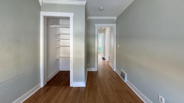 hall with ornamental molding, dark wood-style flooring, visible vents, and baseboards