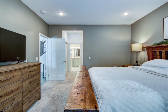 bedroom featuring recessed lighting, ensuite bath, and light colored carpet