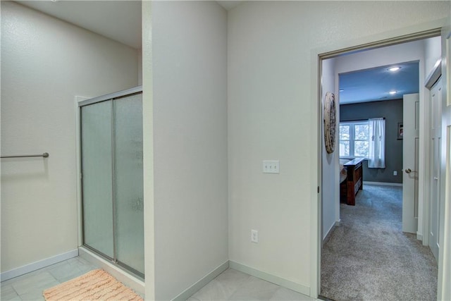 bathroom featuring a stall shower, baseboards, and ensuite bathroom