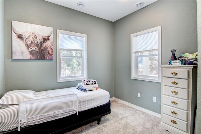 bedroom featuring light carpet and baseboards