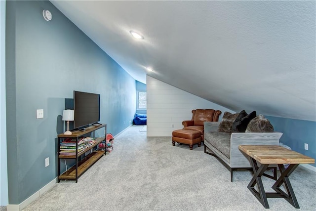 living area featuring lofted ceiling, carpet flooring, and baseboards