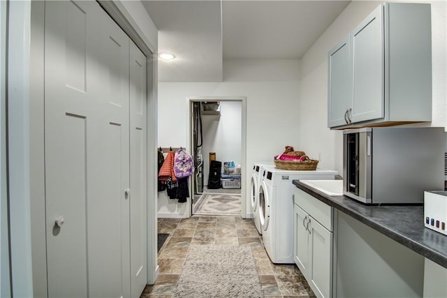 kitchen featuring dark countertops, stone finish floor, and independent washer and dryer