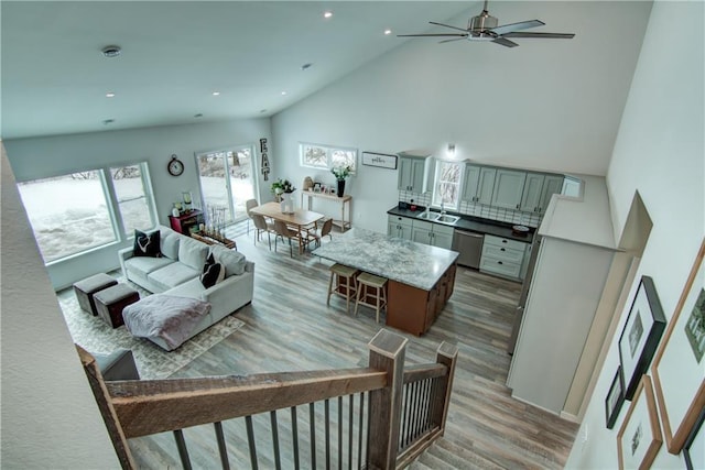 living room featuring light wood-type flooring, high vaulted ceiling, a ceiling fan, and recessed lighting