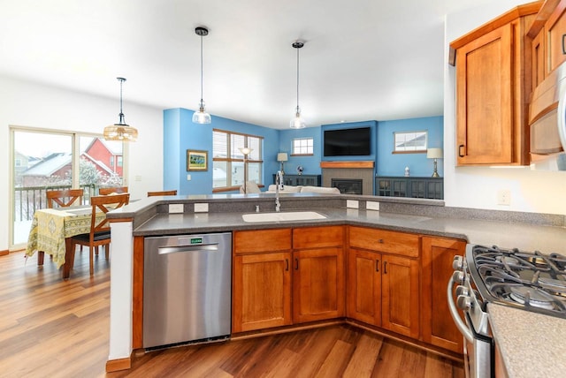 kitchen with appliances with stainless steel finishes, brown cabinetry, and a sink