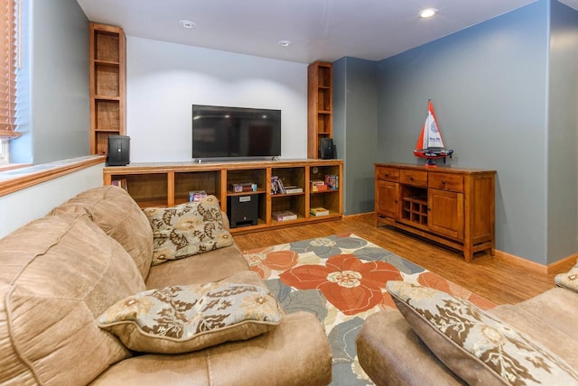 living area featuring baseboards, wood finished floors, and recessed lighting