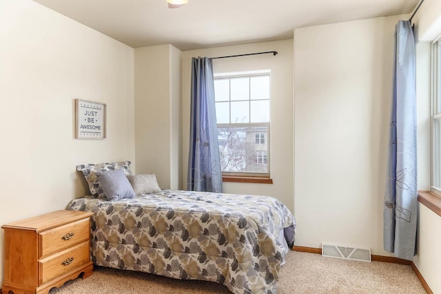 carpeted bedroom with baseboards and visible vents