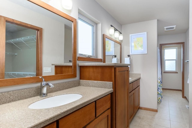 full bath featuring visible vents, vanity, baseboards, and tile patterned floors